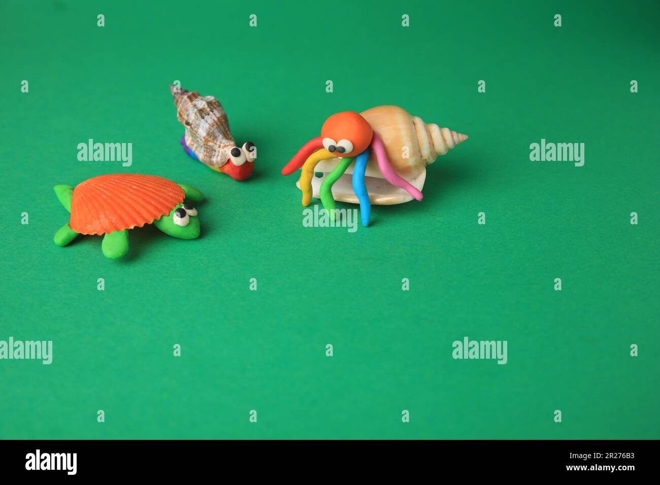 Snail made from plasticine on green background. Children s