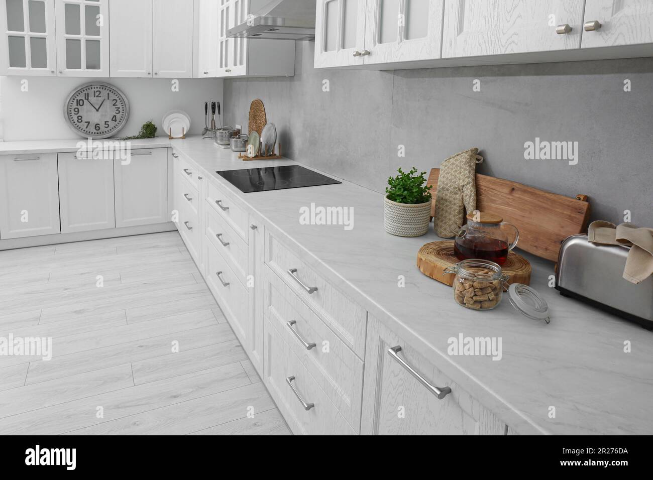 A beautiful kitchen with dark wood cabinets, marble countertops, chairs  sitting at the island, and stainless steel appliances. No brands or names  Stock Photo - Alamy