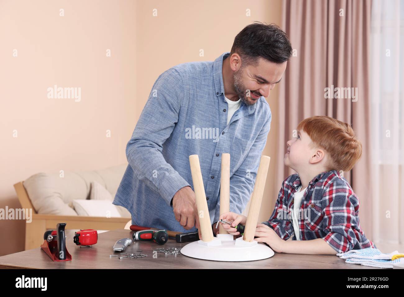 Father teaching son how to make stool at home. Repair work Stock Photo Alamy