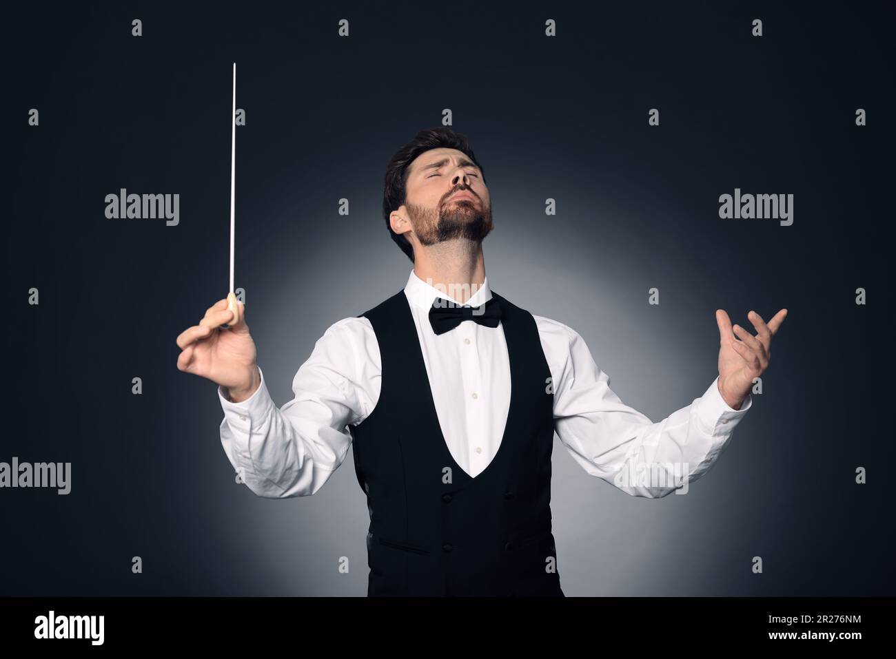 Professional conductor with baton on dark background Stock Photo Alamy
