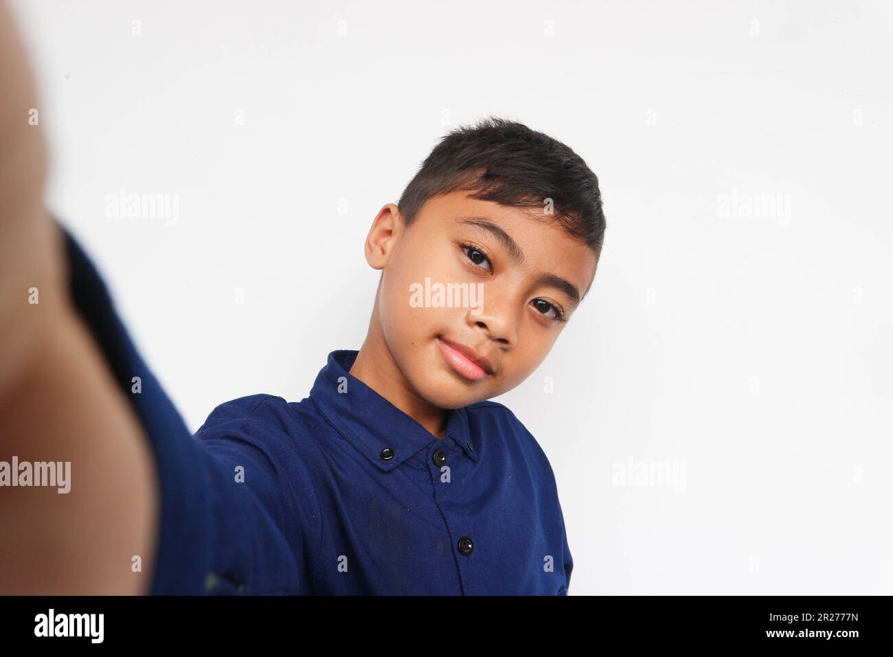 Cute little boy taking selfie on light background. Happy little boy