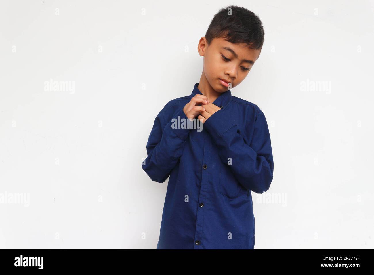 Sad boy wearing blue shirt isolated on white background Stock Photo