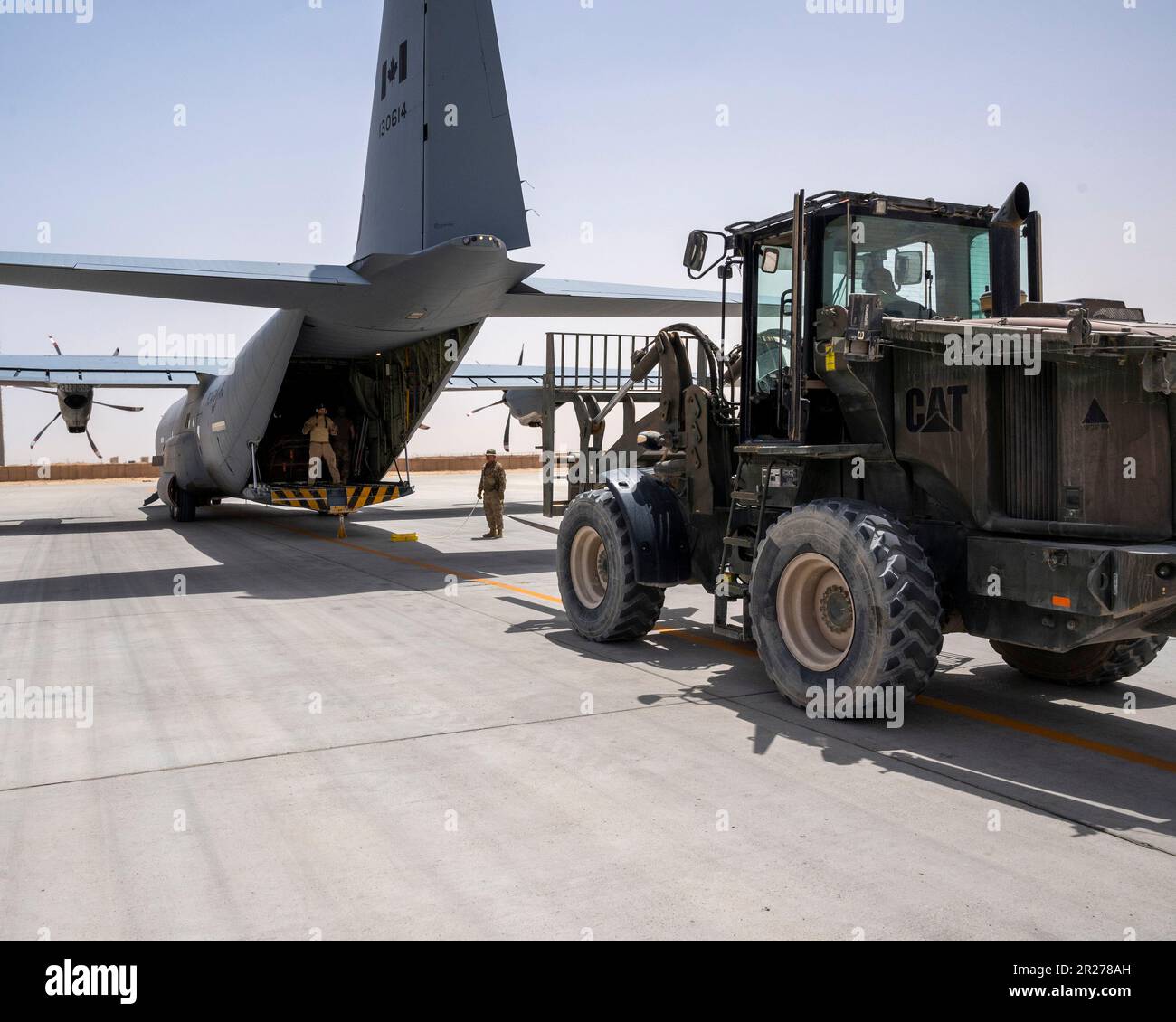 A forklift approaches a Canadian CC-130J Hercules at Al Asad Air Base, Iraq, May 13, 2023.  U.S. and coalition partners work together to ensure cargo is properly loaded for transit. Shipments like this supply forces in the field with the equipment needed to sustain missions around the U.S. Air Force Central Command area of responsibility. (U.S. Air Force photo by Senior Airman Nicholas Larsen) Stock Photo