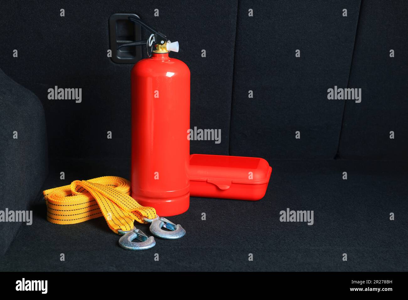 Fire extinguisher, towing strap and first aid kit in trunk, space for text. Car safety equipment