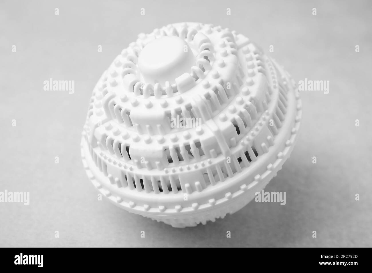 Dryer ball for washing machine on light grey table, closeup. Laundry detergent substitute Stock Photo