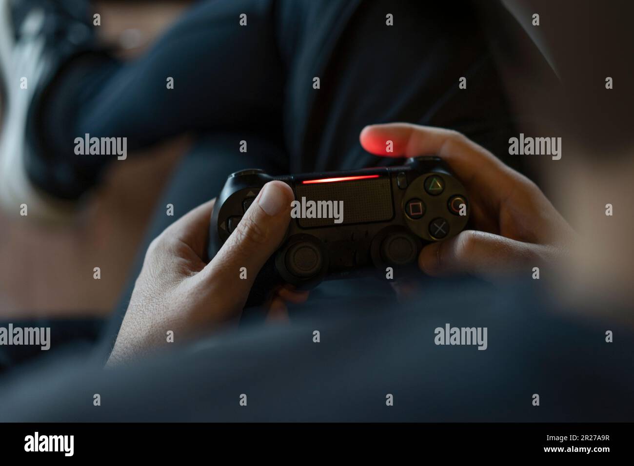 Close-up of an adult man's hands holding a joystick while playing a video game on a console. Stock Photo