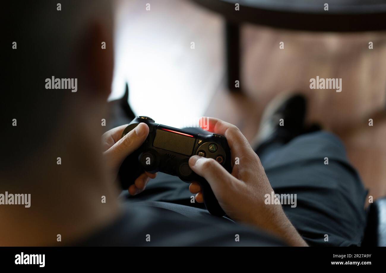 Gamer using controller to play online video games on computer. Man playing  game with joystick and headphones in front of monitor. Player having gaming  equipment, doing fun activity Stock Photo - Alamy