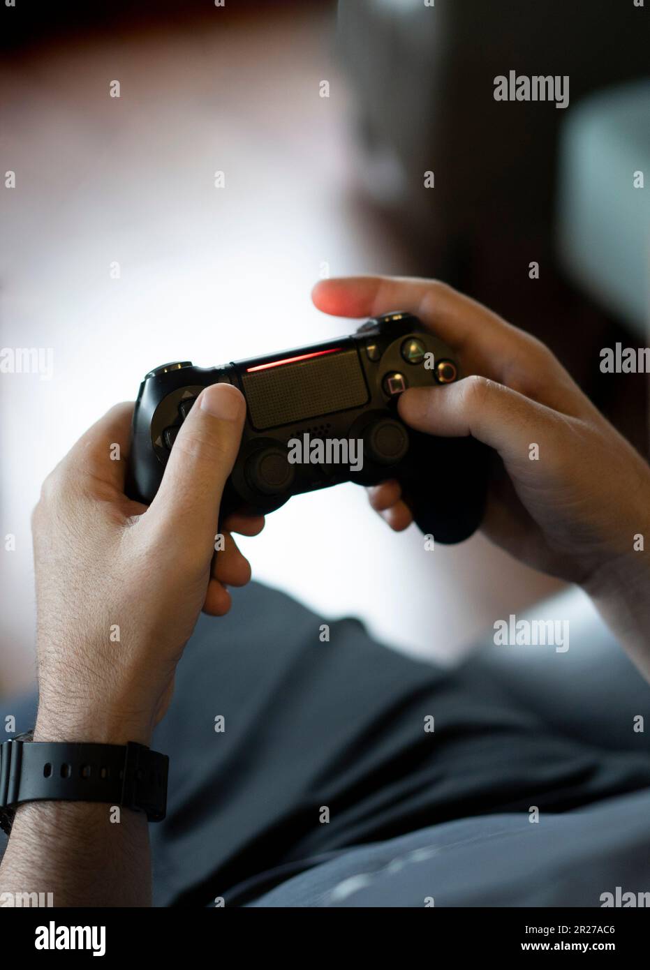 High angle view of an adult man's hands holding a joystick while playing a video game on a console Stock Photo