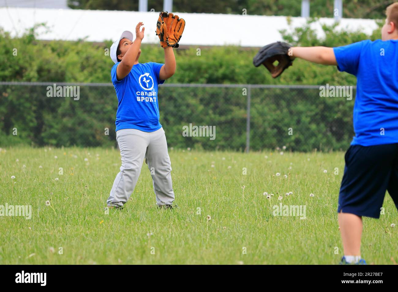 African American preteen boy attempting to catch a pop fly in the