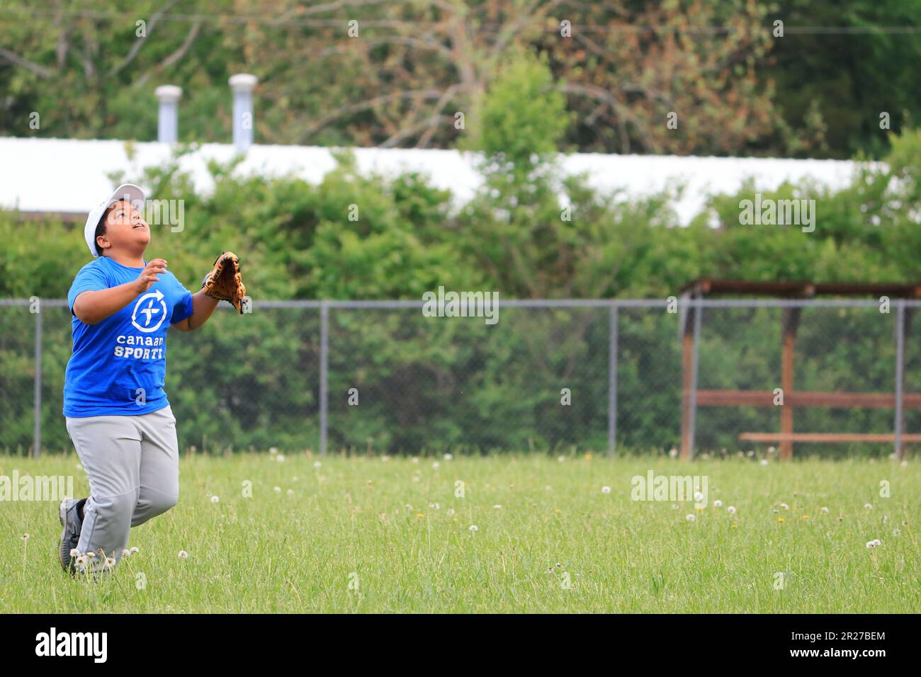 African American preteen boy attempting to catch a pop fly in the