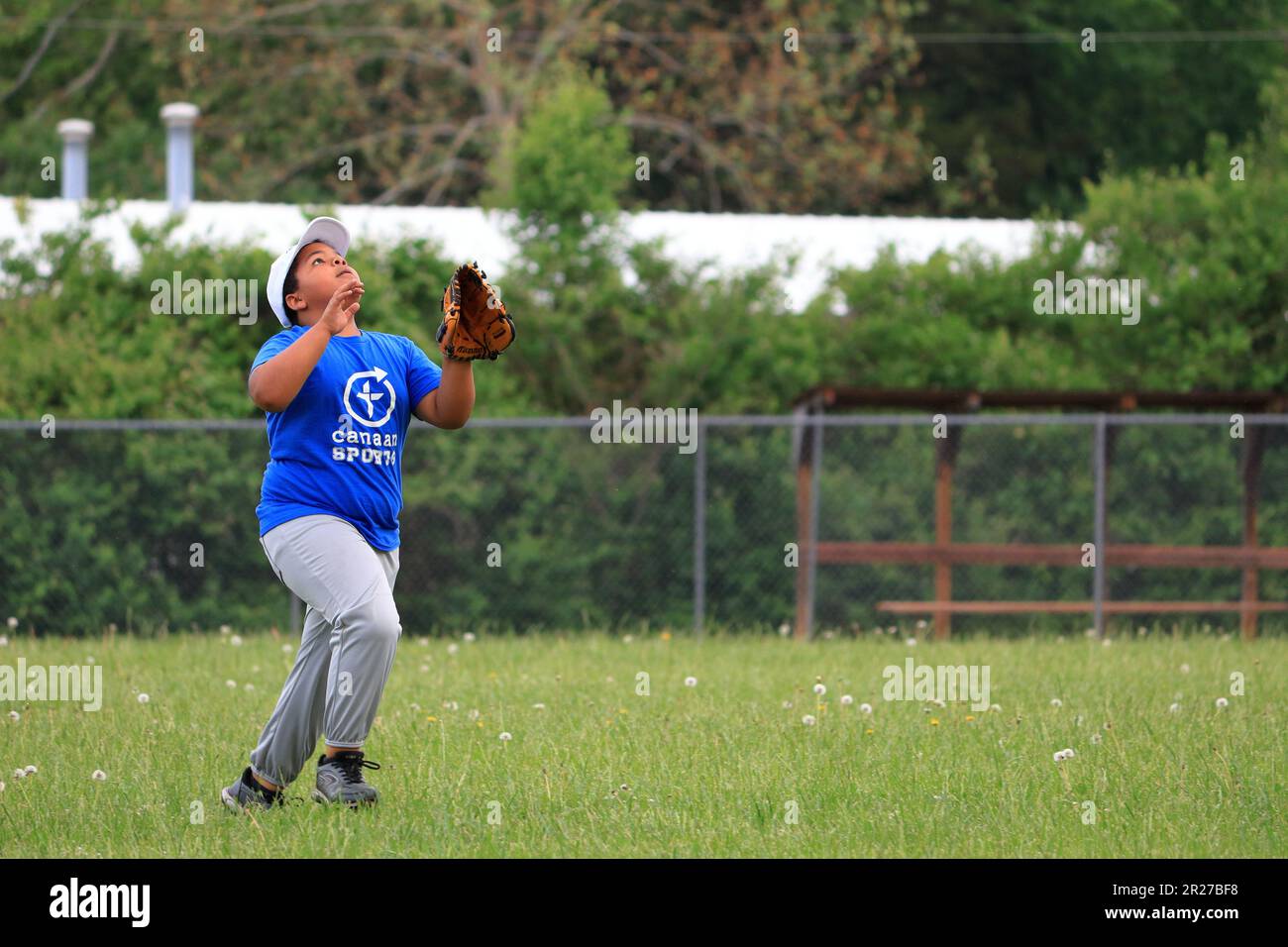 African American preteen boy attempting to catch a pop fly in the