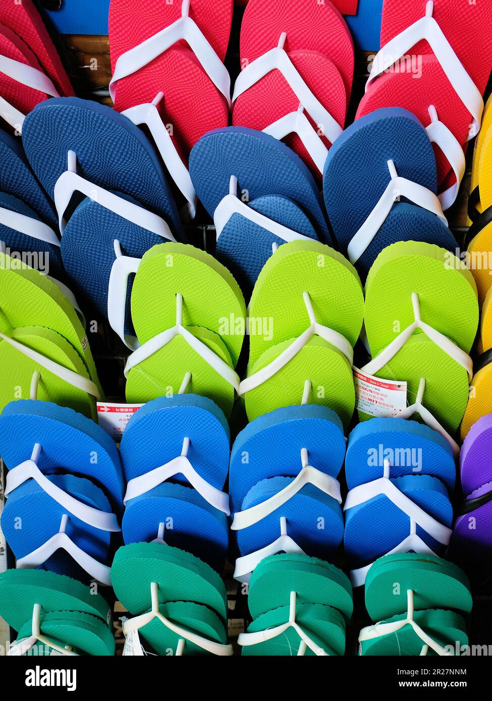 Rows of  many colorful flip flops for sale on the Island of Xiaoliuqiu in Taiwan, ROC; comfortable beachwear or footwear. Stock Photo