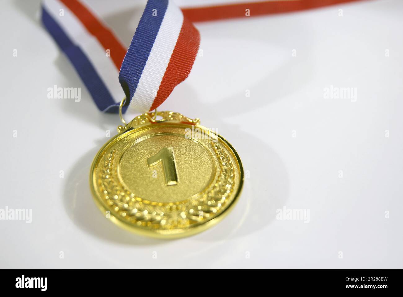 Gold medal 1 place with a ribbon on a light gray background, the concept of victory or success Stock Photo