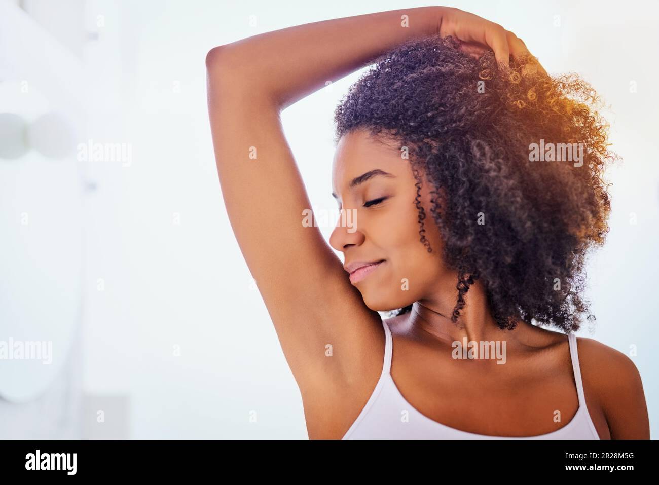 African woman, smell armpit and bathroom in home with smile, fragrance