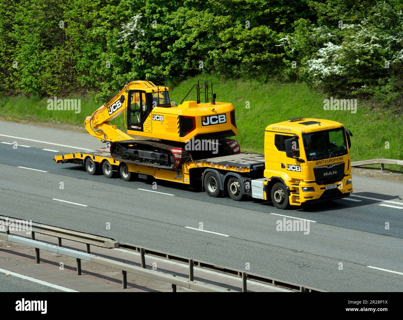 JCB low-loader lorry on the M40 motorway, Warwickshire, UK Stock Photo