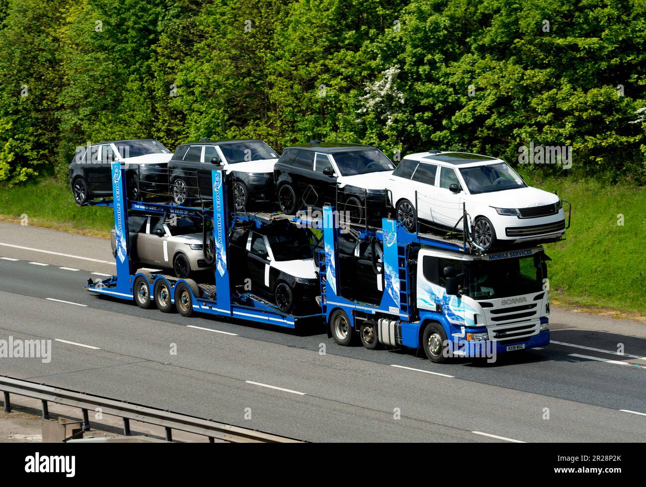 Mobile Services transporter lorry carrying new Land Rover cars on the M40 motorway, Warwickshire, UK Stock Photo