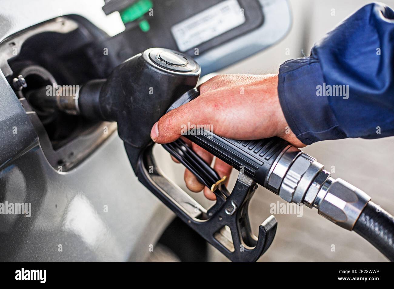Refueling the car at a gas station fuel pump. Man hand refilling and