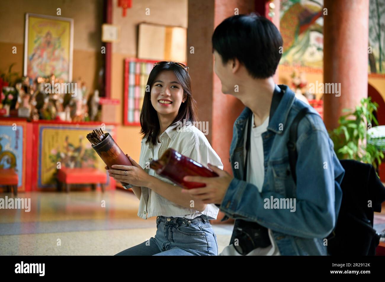 Happy young Asian couple prays for luck and shakes Chinese fortune ...