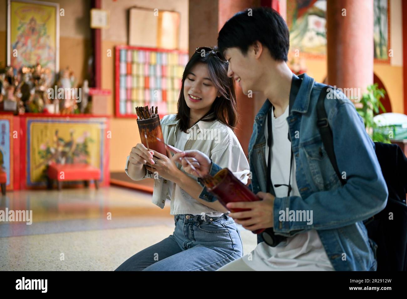 Happy and cute young Asian tourist couple prays for good luck and ...