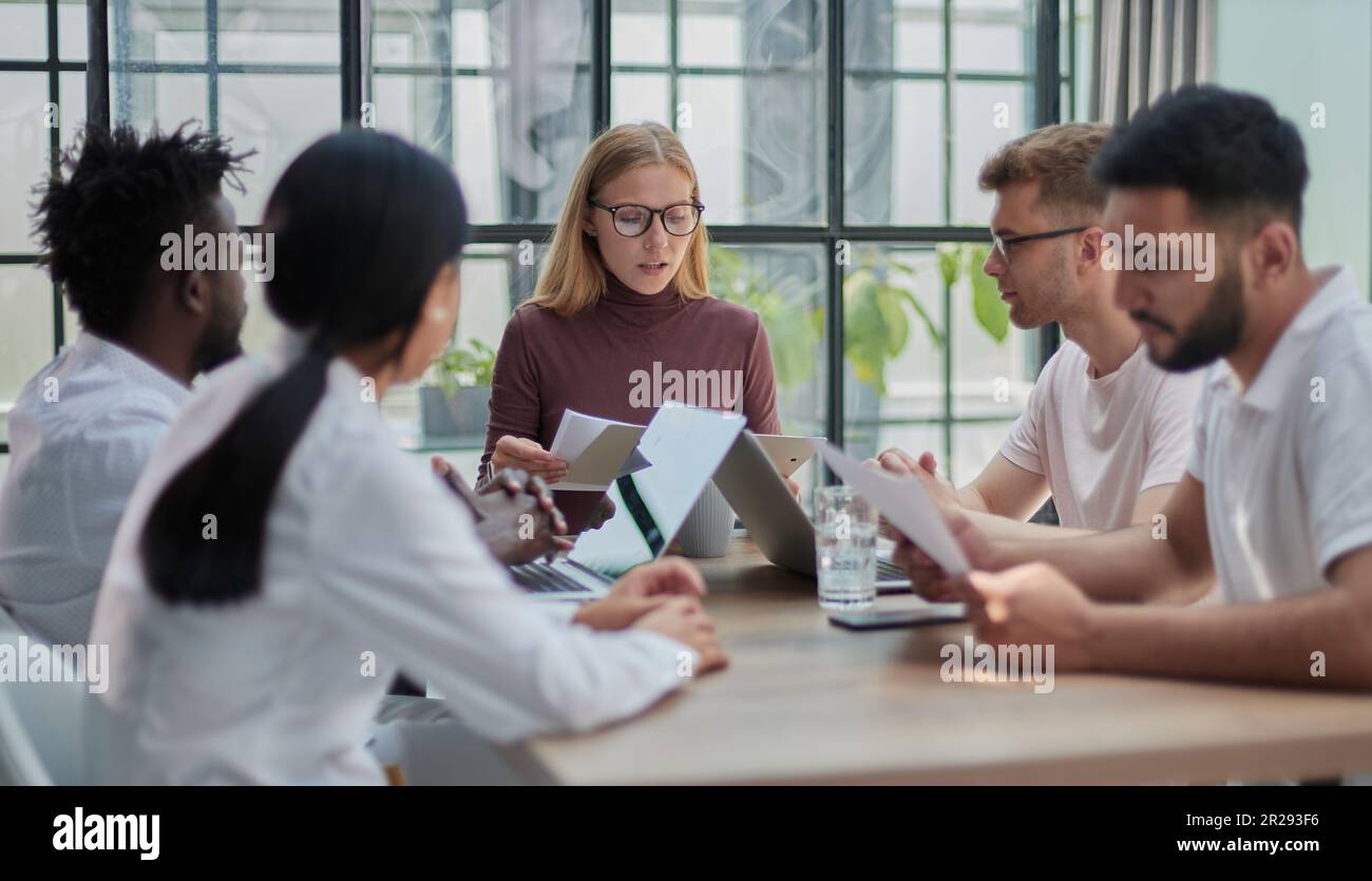Team Working At Desks In Busy Office Stock Photo