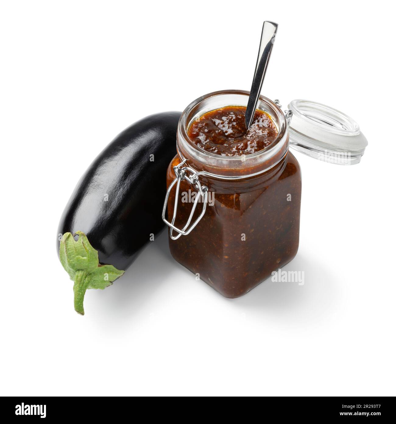 Glass jar with eggplant chutney and a fresh purple eggplant on the side
