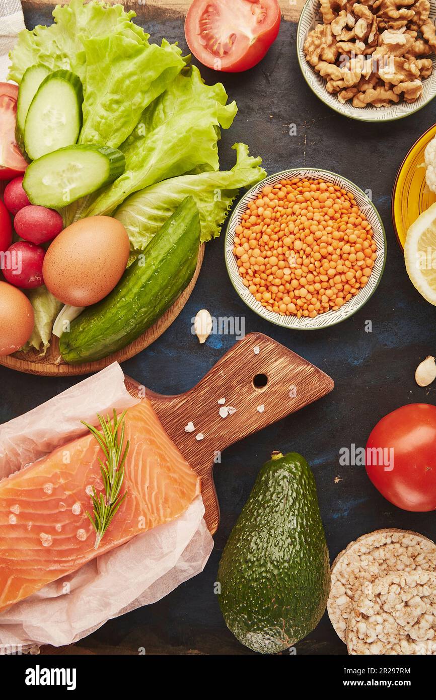 Fodmap Mediterranean diet. Healthy low fodmap food ingredients - vegetables, fruits, walnuts, salmon, greens, avocado. Flat lay Stock Photo