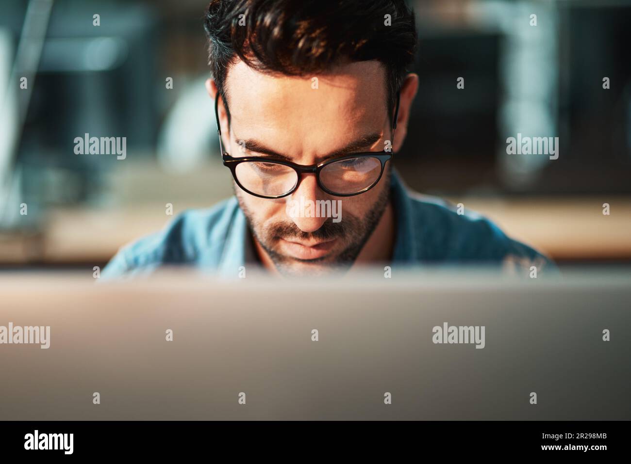 Serious man, face and glasses at computer in office for planning software update, online