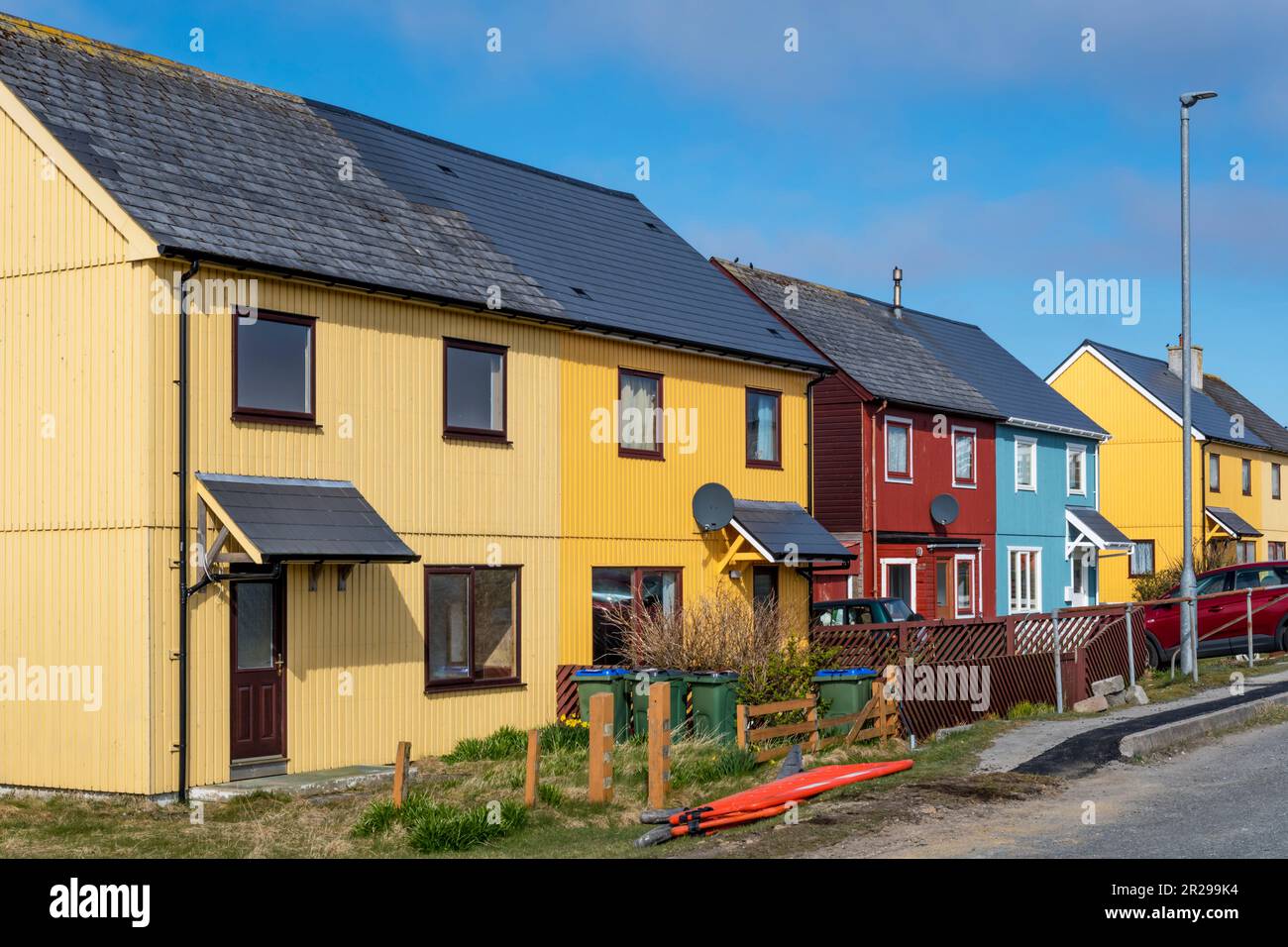 Bright coloured cladding on houses at Burravoe in the south of the island of Yell, Shetland