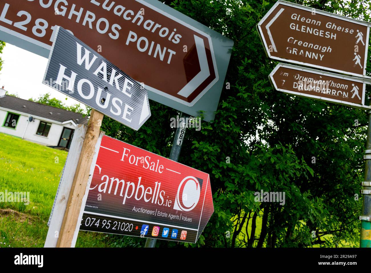 Wake House sign amongst other road signage in Ardara, County Donegal, Ireland Stock Photo
