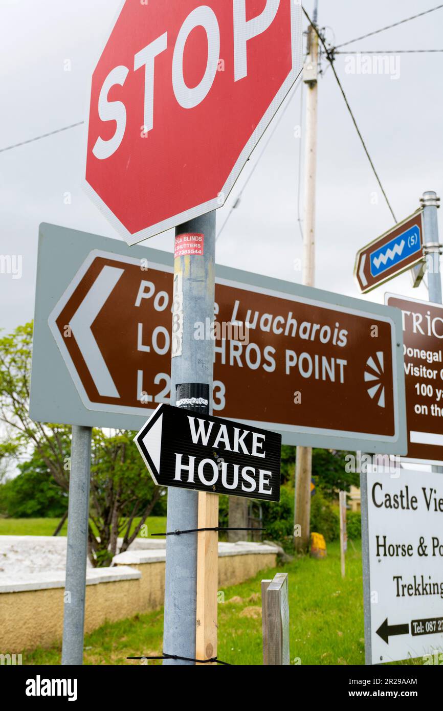Wake House sign amongst other road signage in Ardara, County Donegal, Ireland Stock Photo