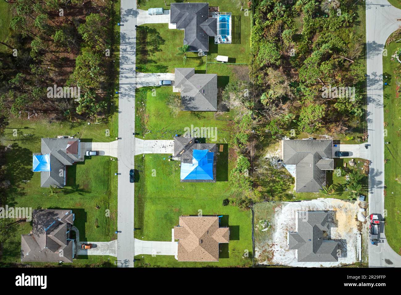 Aerial view of damaged in hurricane Ian house roofs covered with blue