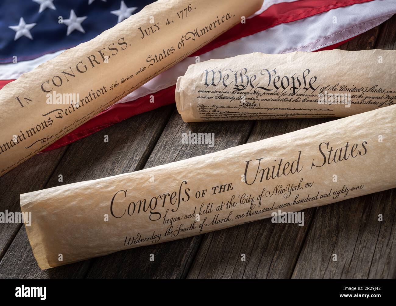 Charters of freedom, the declaration of independence, constitution and bill of rights with american flag on wooden background Stock Photo