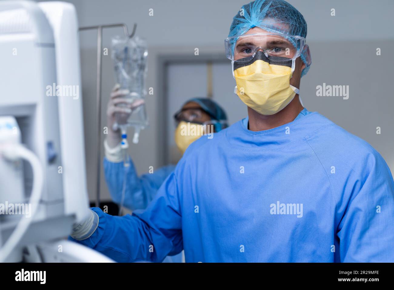 Portrait of caucasian male surgeon preparing equipment for surgery in ...