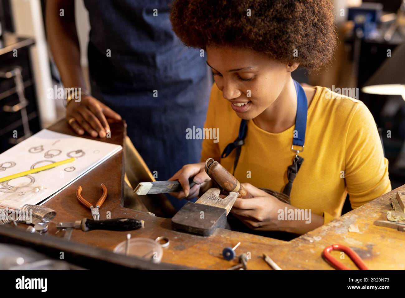 Happy diverse workers making jewellery using tools at jewellery 