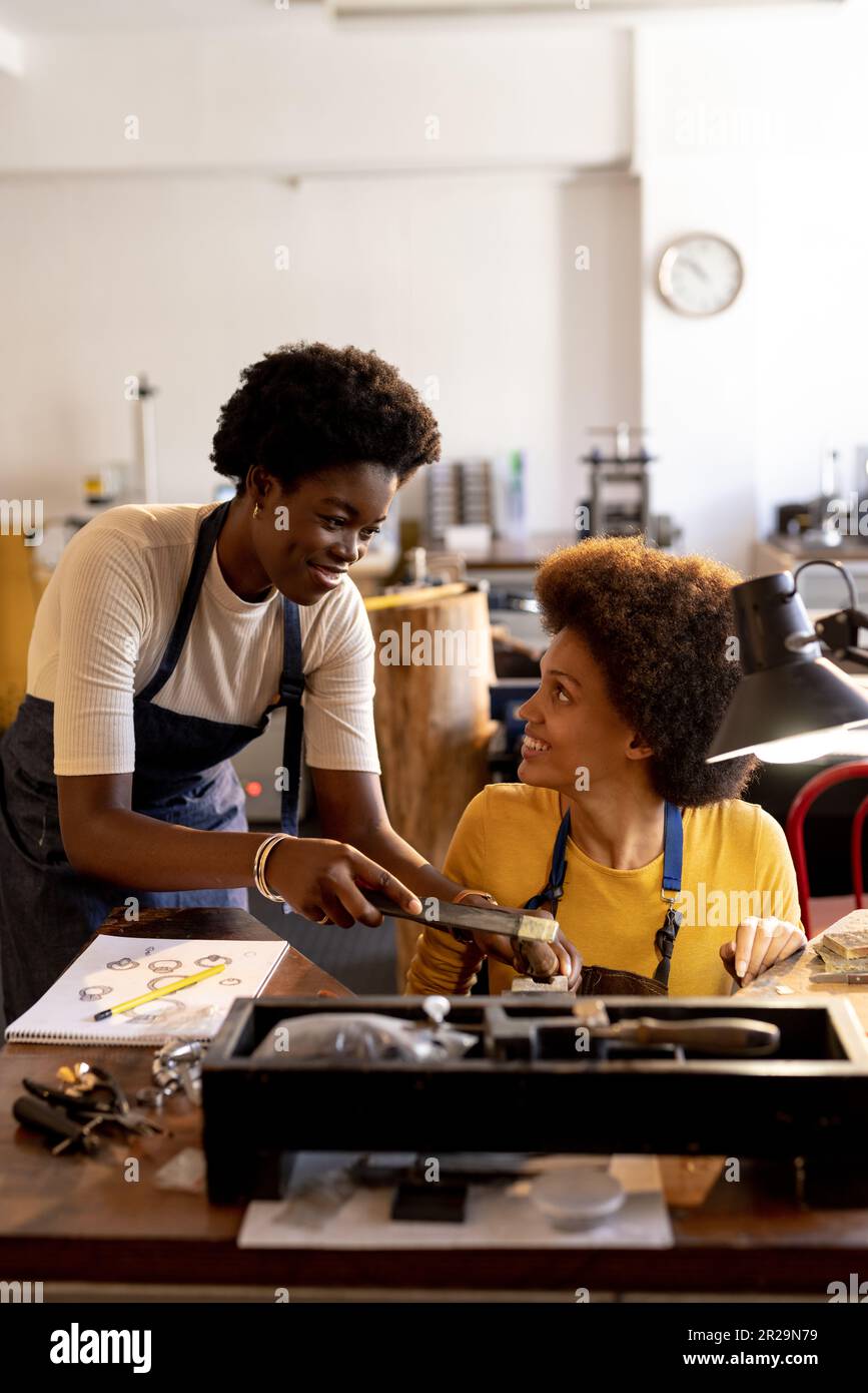 Happy diverse workers making jewellery using tools at jewellery 