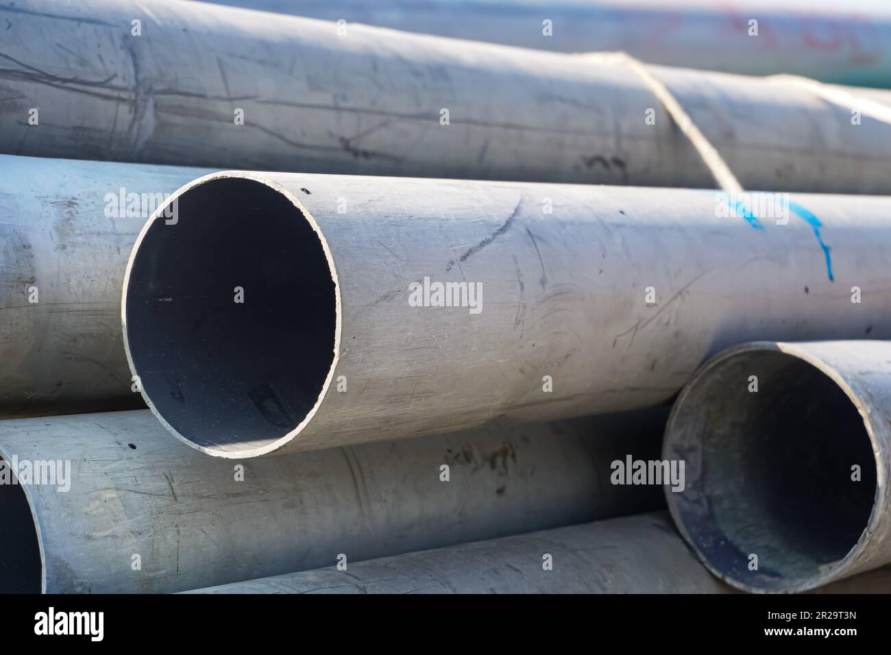 Close up gray plumbing plastic pipes. The many big pipes on the ground