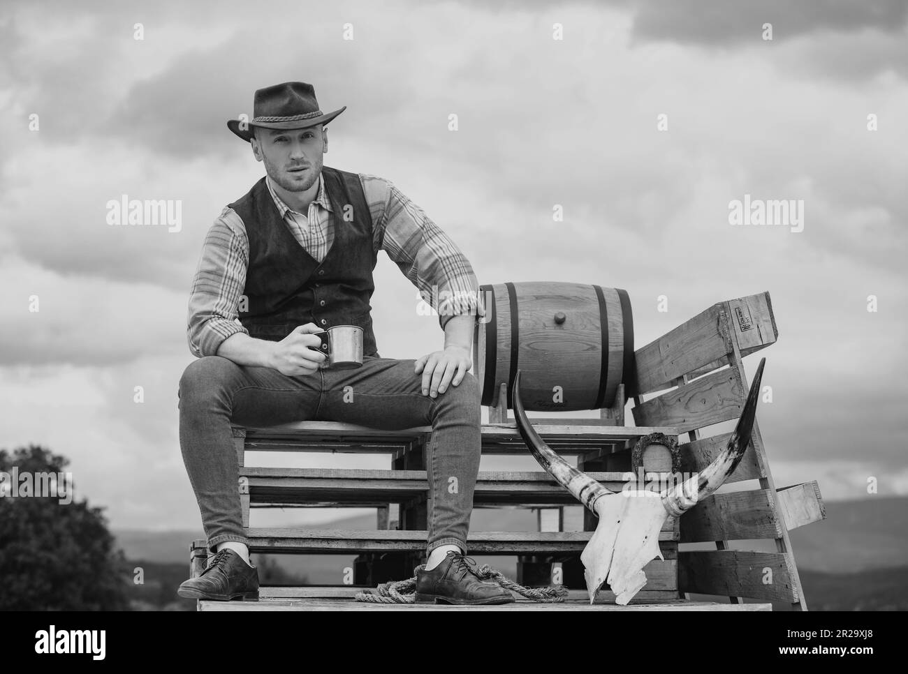 Farmer cowboy hold cup coffee or tea. Western life. American country male portrait. Farm owner worker in countryside on farm or ranch. Stock Photo