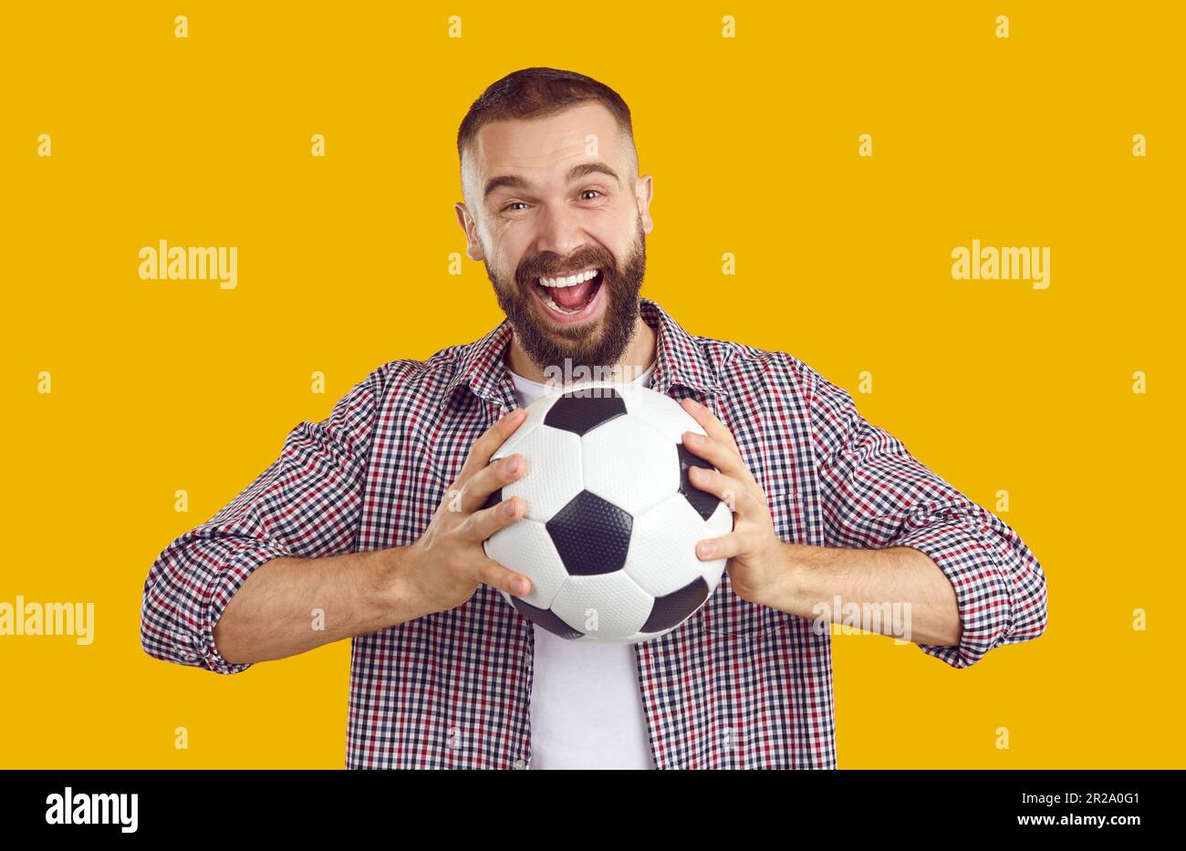Portrait of a happy, excited young man holding a soccer ball isolated ...
