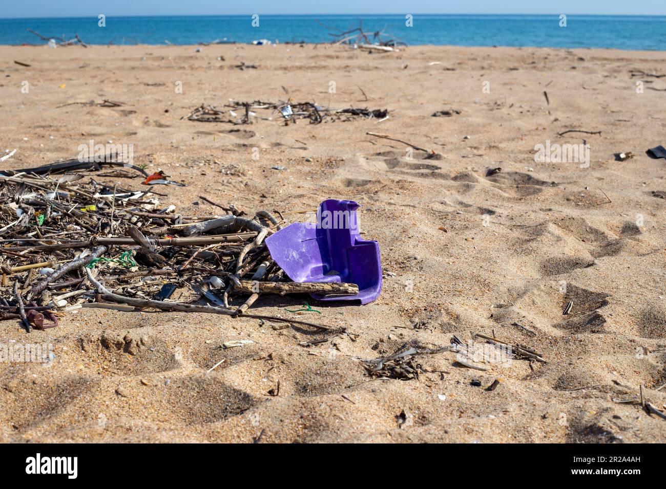 Sandy beach with a lot of garbage on the shore. Ecological catastrophy. Stock Photo