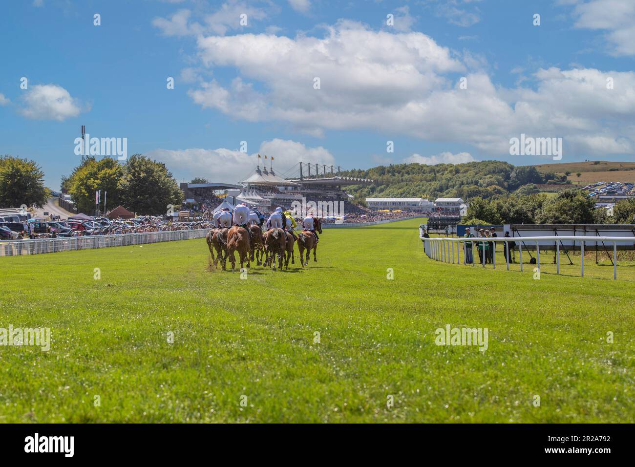 Horses and jockeys approaching the finishing line and going past the