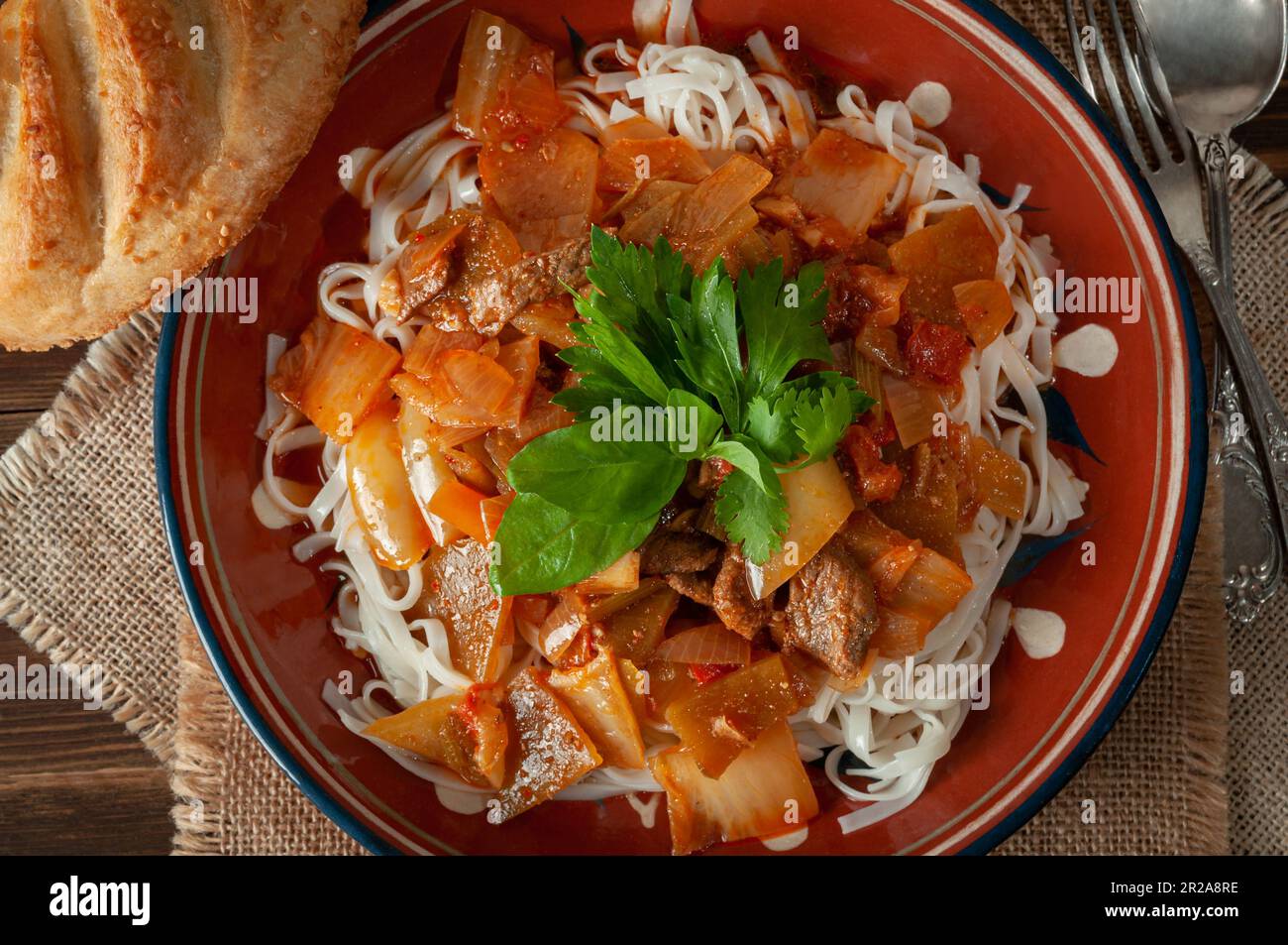 Hot Uighur dish served with herbs and flatbread. Stock Photo
