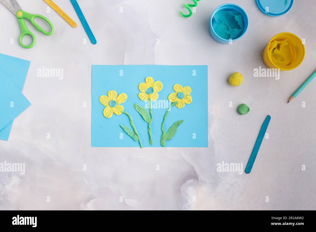 Blue and yellow flowers from plasticine. Kid's craft with dough clay. Colorful clay Stock Photo