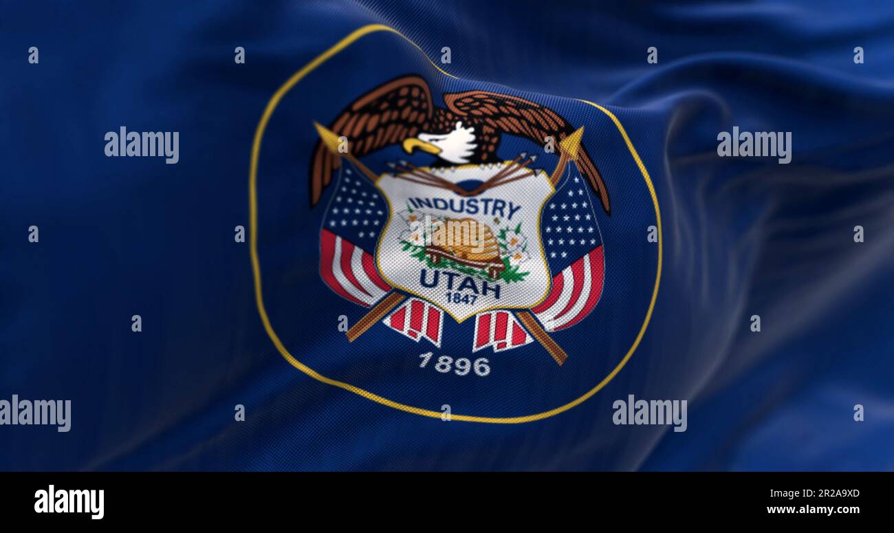 Utah state flag fluttering in the wind. State seal surrounded by a