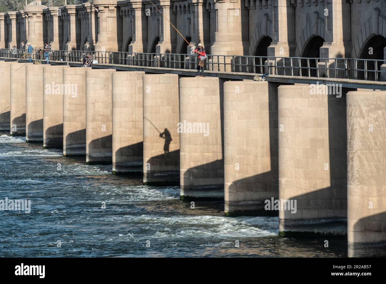 Egyptian men fishing from the El Qanater Barrage, on the River Nile at