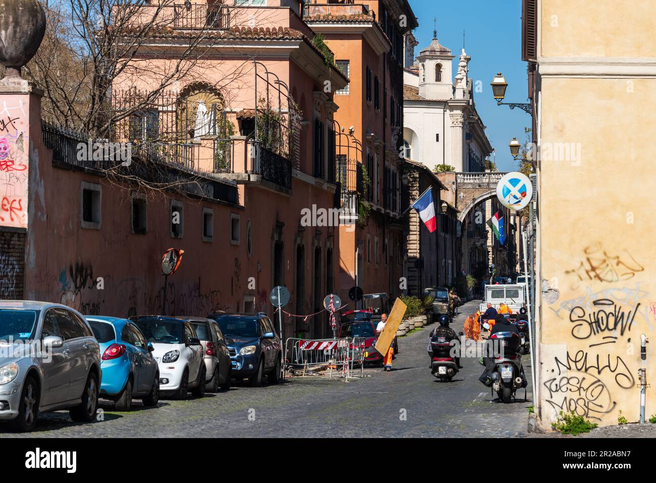 Rom, Italien, März 2023 Straßenszene morgendlicher Straßenverkehr auf der Via Giuglia, eine Baustelle ein Bauarbeiter trägt ein Brett Stock Photo