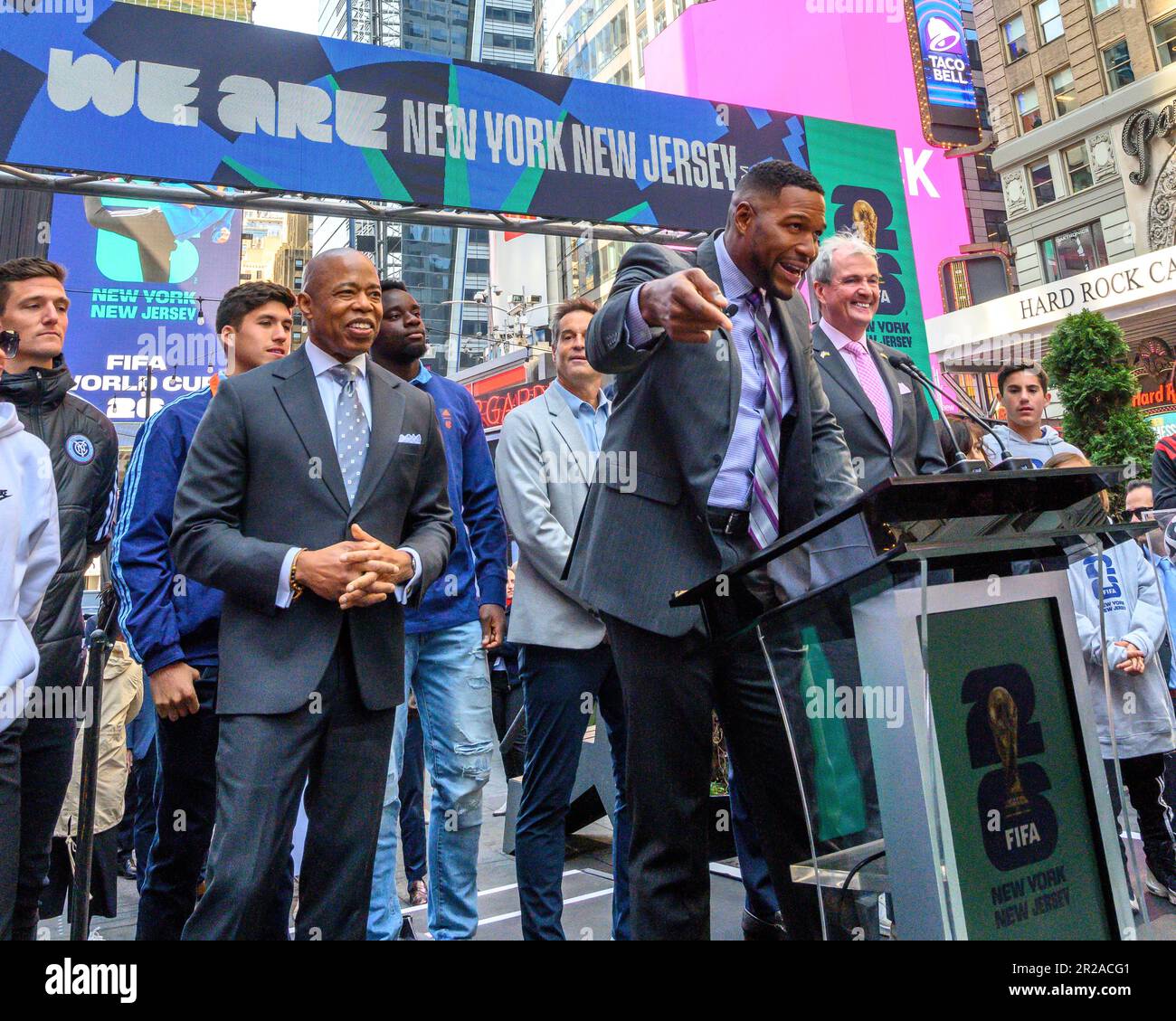 New York, USA. 18th May, 2023. Former footballer Michael Strahan (C) is flanked by New York City Mayor Eric Adams (L) and New Jersey Governor Phil Murphy (R) at a FIFA World Cup 2026 New York/New Jersey Launch Event in Times Square. The event unveiled the official themes for the MetLife stadium matches: 'We are NYNJ' and 'We are 26'. The world's top soccer competition is already planning to host 8 matches in the New York/New Jersey area and the local organizers want to host the final game here too. Credit: Enrique Shore/Alamy Live News Stock Photo