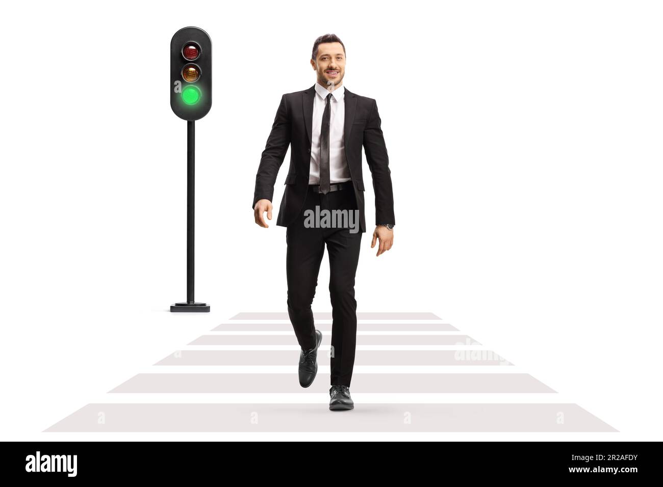 Full length portrait of a businessman crossing street at green traffic