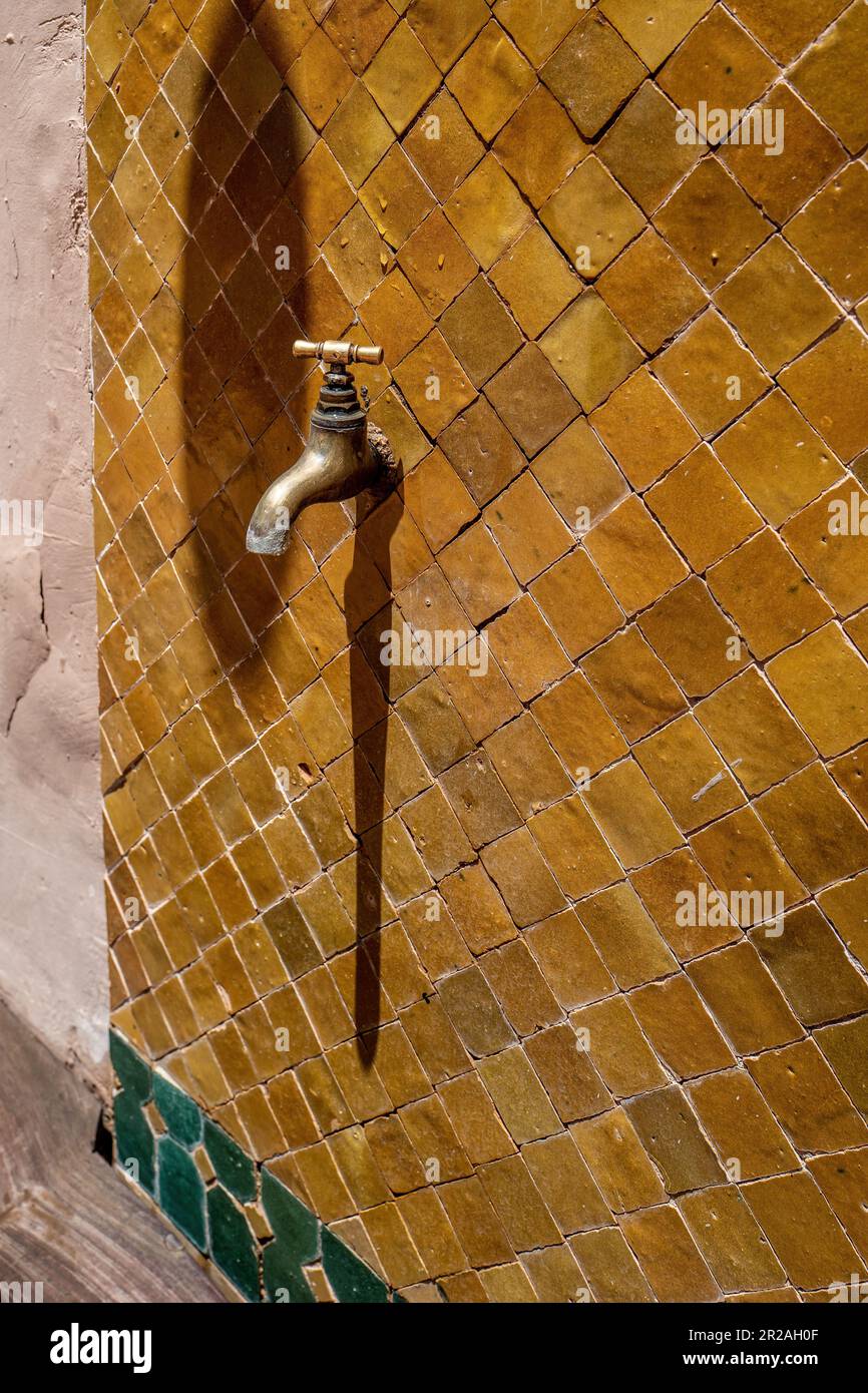 Old brass water tap isolated on an amber tiled background. tap valve. old brass retro faucet,. plumbing, repair,. Vintage close-up Stock Photo