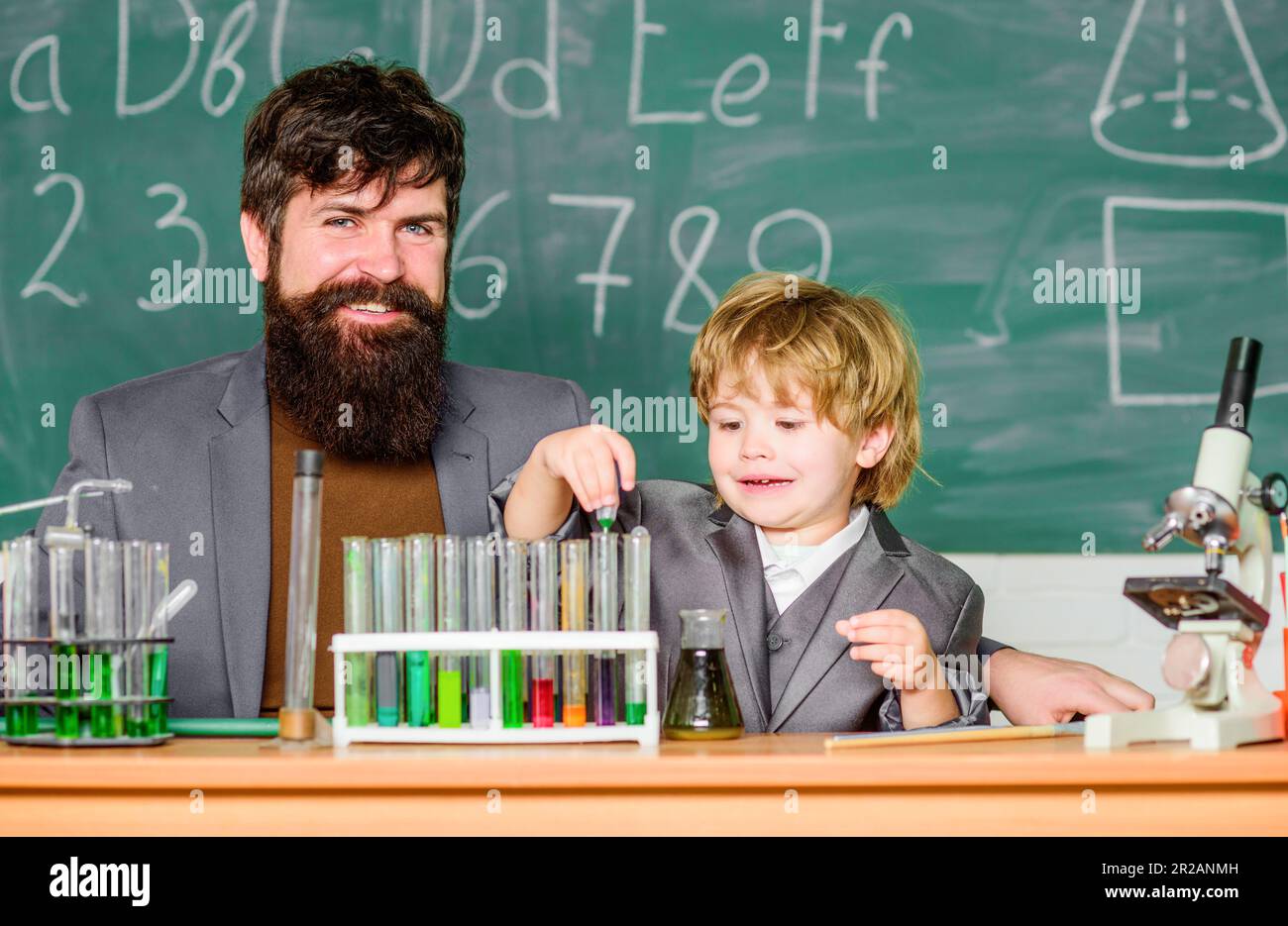 Laboratory test tubes and flasks with colored liquids. father and son ...