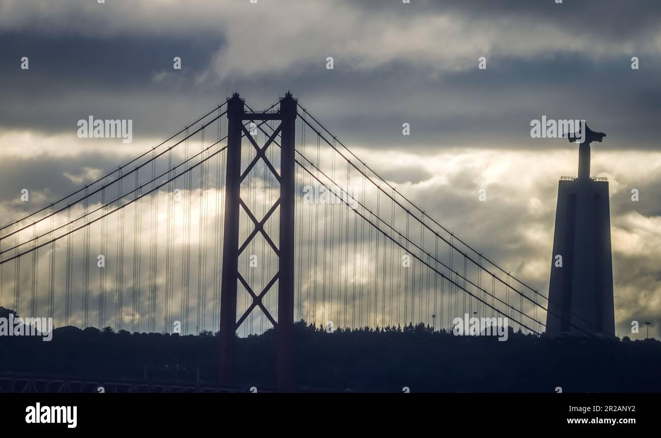 Cloudy morning with bridge in Lisbon and Christ statue. Ponte de 25 abril e Cristo Rei. Stock Photo